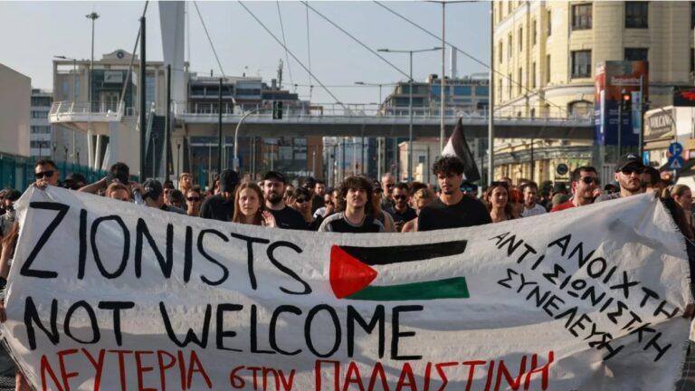 Pro-Palestinian demonstrators carry a banner during a protest against the arrival of an Israeli cruise ship in the port of Piraeus near Athens, Greece, June 12, 2025. (photo credit: REUTERS/Louisa Gouliamaki)